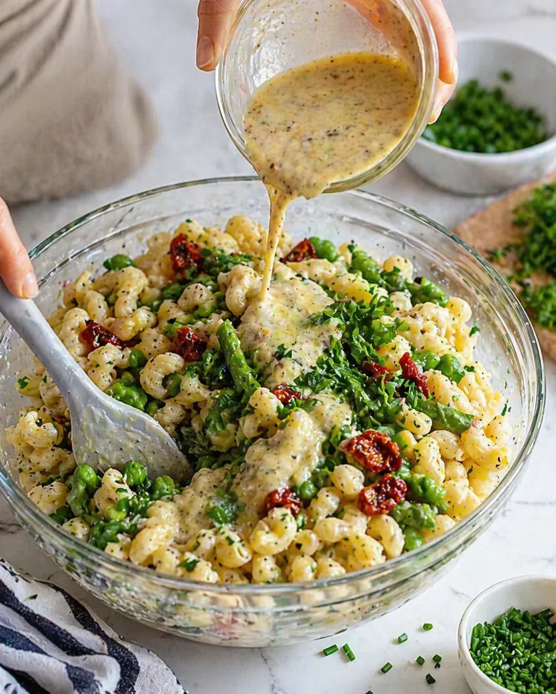 Creamy herb sauce poured over gnocchi-like pasta with peas and sun-dried tomatoes.
