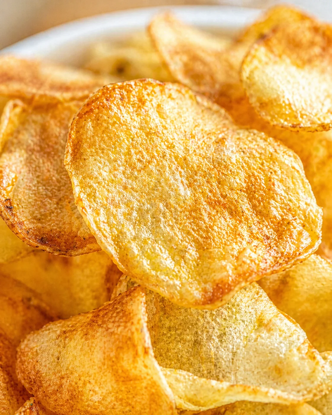 close-up of golden brown crispy potato chips piled in a bowl