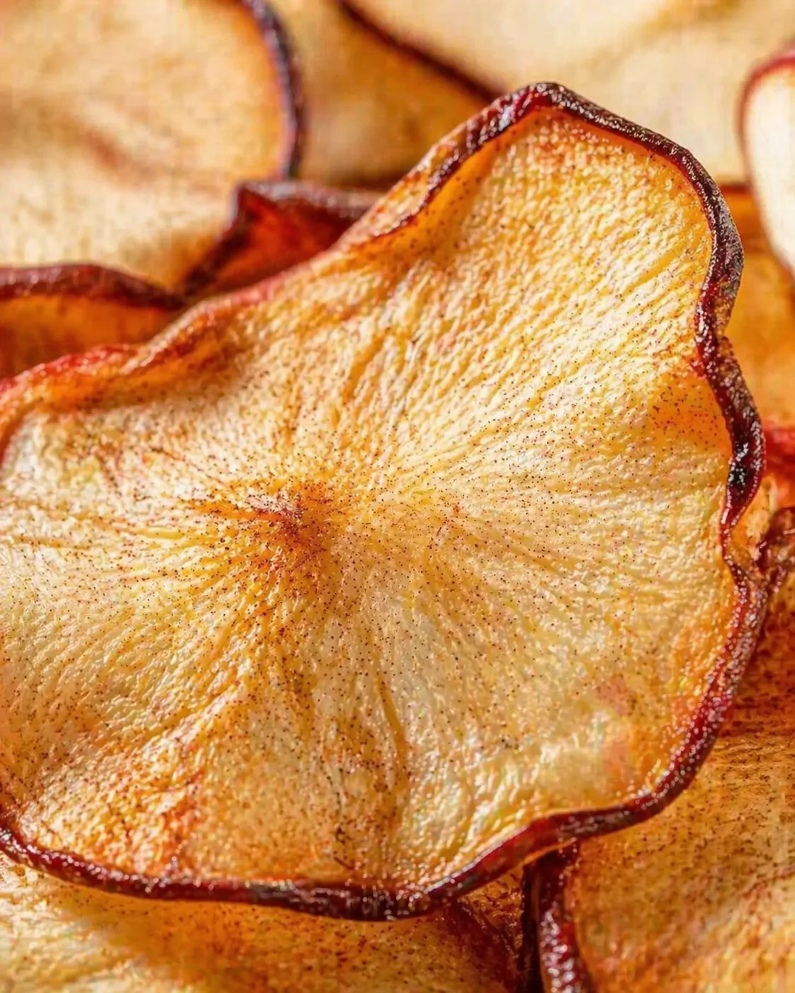 Close-up of dried pear slices on a wooden surface with amber edges