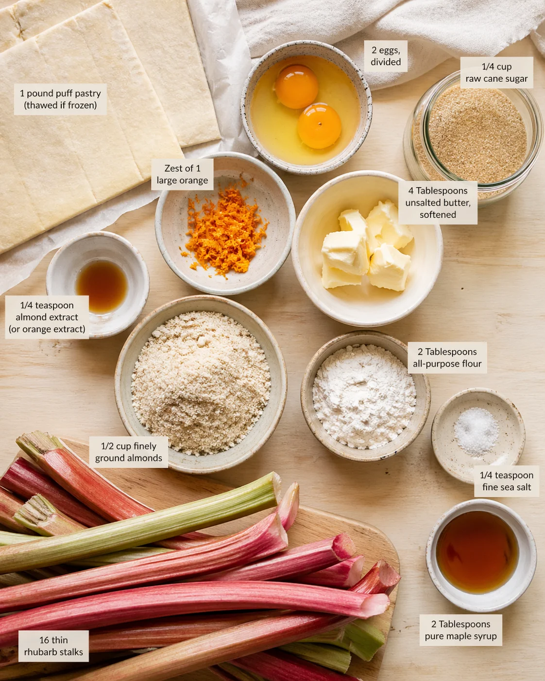 Top-down view of rhubarb stalks and baking ingredients arranged on a light wooden surface for recipe prep.
