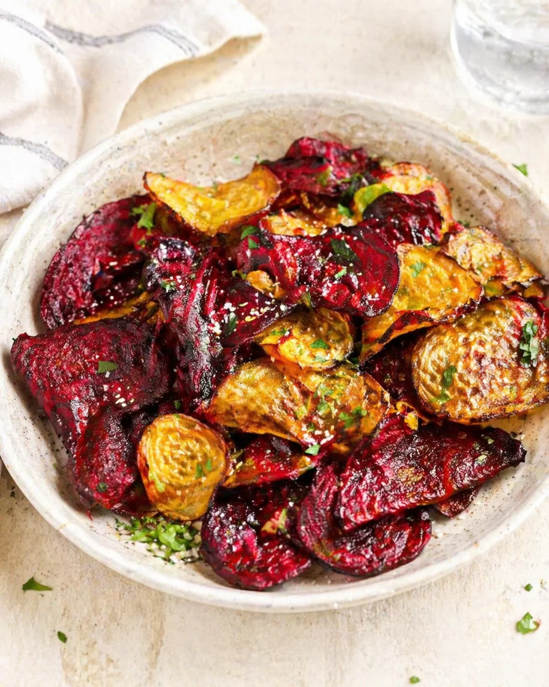 bowl of roasted beets and potatoes with herbs in a rustic ceramic bowl